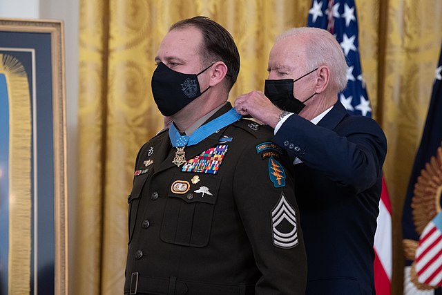 President Joe Biden placing the Medal of Honor around Master Sergeant Earl Plumlee's neck