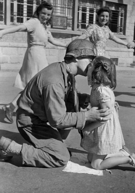 US soldier kissing a little girl on the cheek