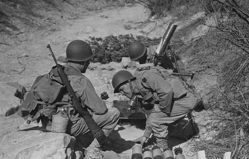 81 mm mortar crew in action at Camp Carson, Colorado, April 24, 1943. The soldier on the left has a slung M1 carbine. (Photo Credit:  U.S. National Archives and Records Administration / Public Domain)