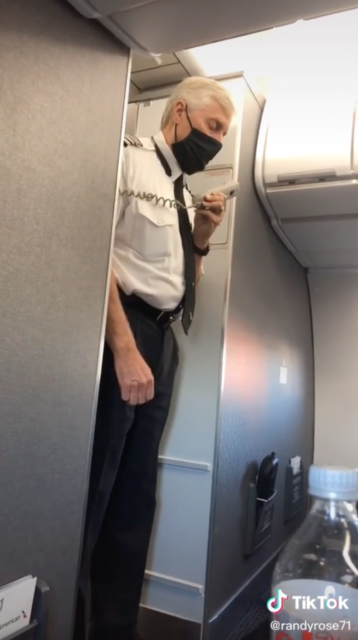 Pilot bowing his head while holding a telephone