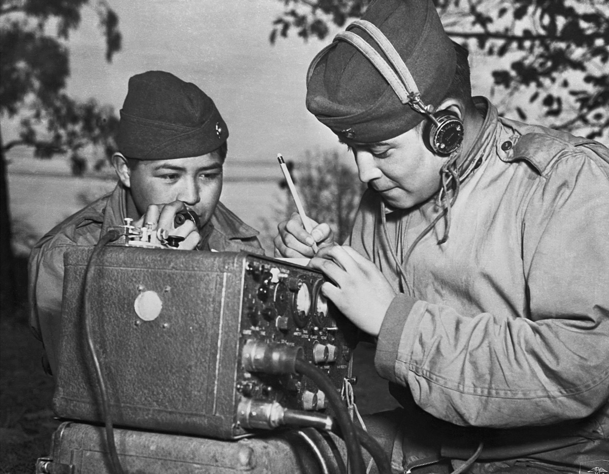 A two-man team of Navajo code talkers attached to a Marine regiment in the Pacific relay orders over the field radio using their native language.(Photo by © CORBIS/Corbis via Getty Images)