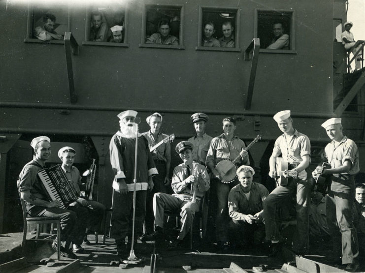 Service band and Santa Claus sitting in front of a train