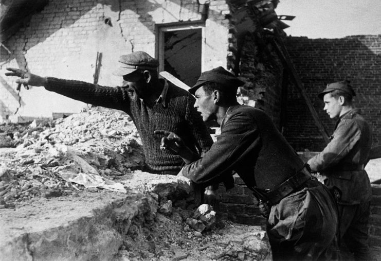 Elderly man pointing out a location to two Scouts