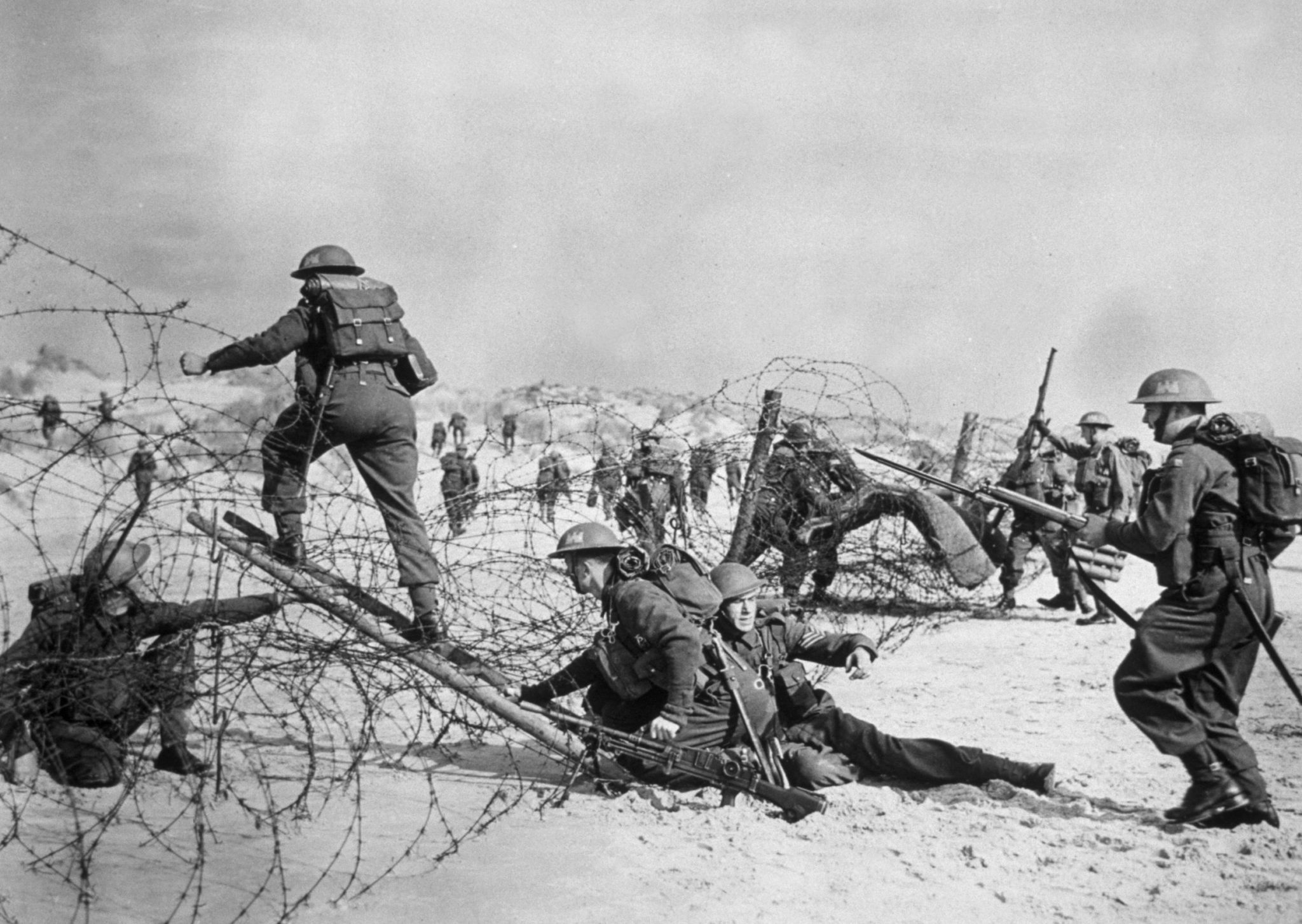 1940:  British soldiers negotiating a barbed wire defence during a seashore invasion exercise.  (Photo by Hulton Archive/Getty Images)