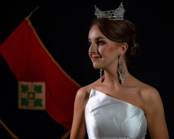 Spc. Maura Spence-Carroll wearing a silver dress and crown