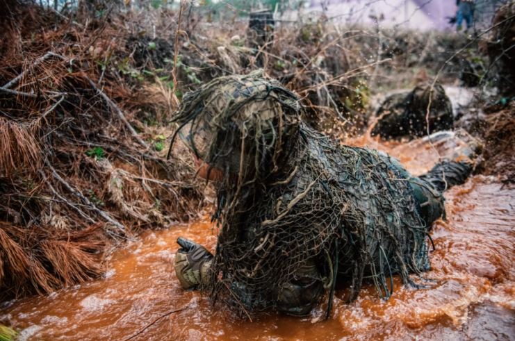 US Army Sniper School trainee in the ghillie wash