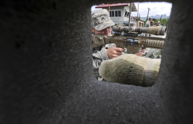 US Army Mobile Sniper School trainee aiming a sniper rifle