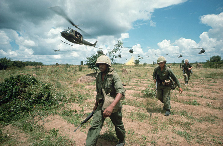 US Infantrymen walking beneath helicopters