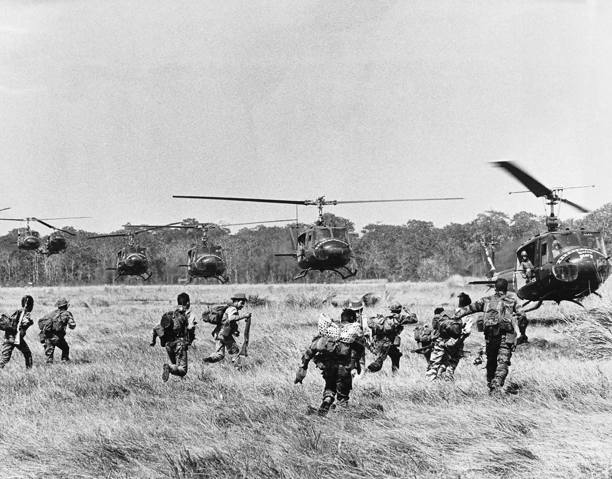 A United Stated Army Special Forces team trooper, along with members of his strike force and Chinese Nung fighters, run towards helicopters as they prepare for an assault on a Vietcong held village. (Photo by © Wally McNamee/CORBIS/Corbis via Getty Images)