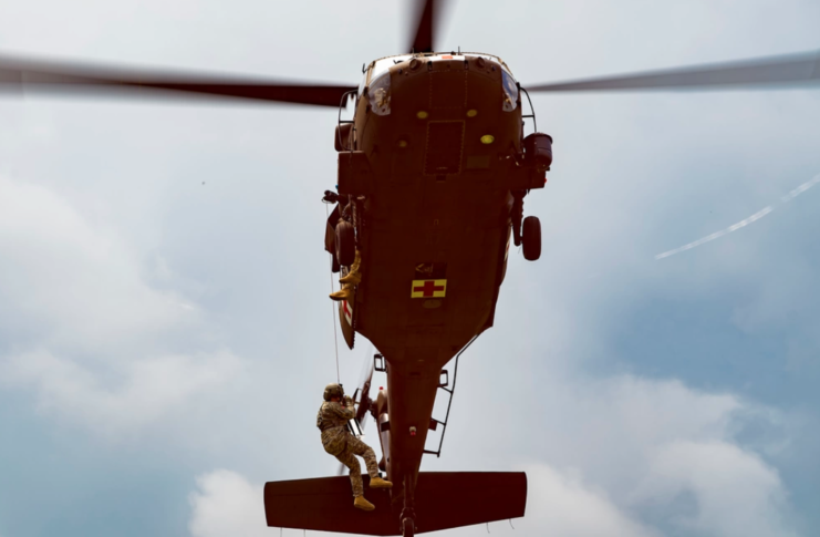 Member of the West Virginia Air National Guard repelling from a helicopter