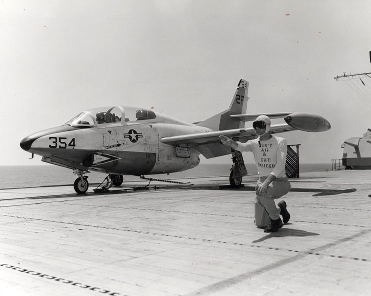 US Navy personnel guiding a T-2J Buckeye