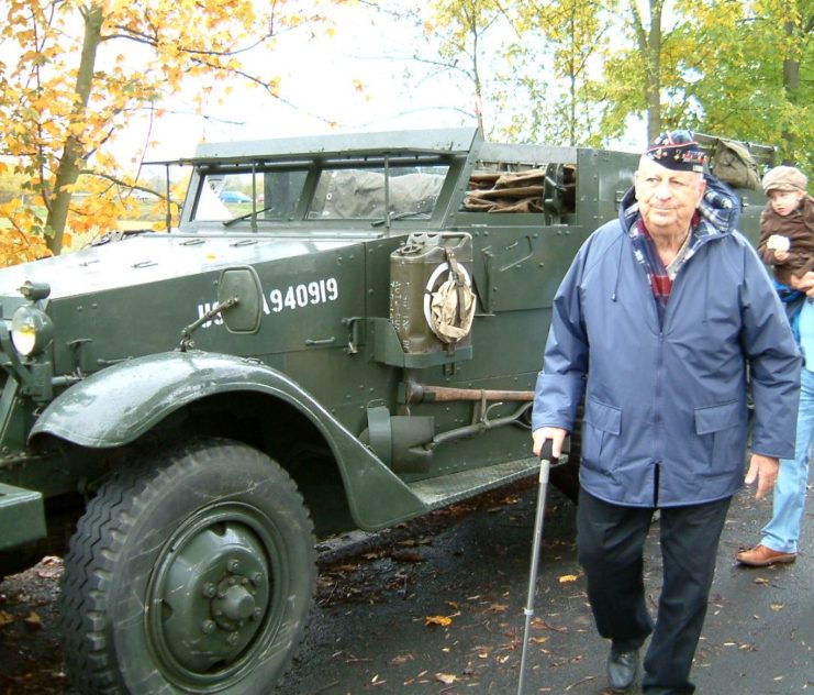 Abraham Baum walking past a Jeep