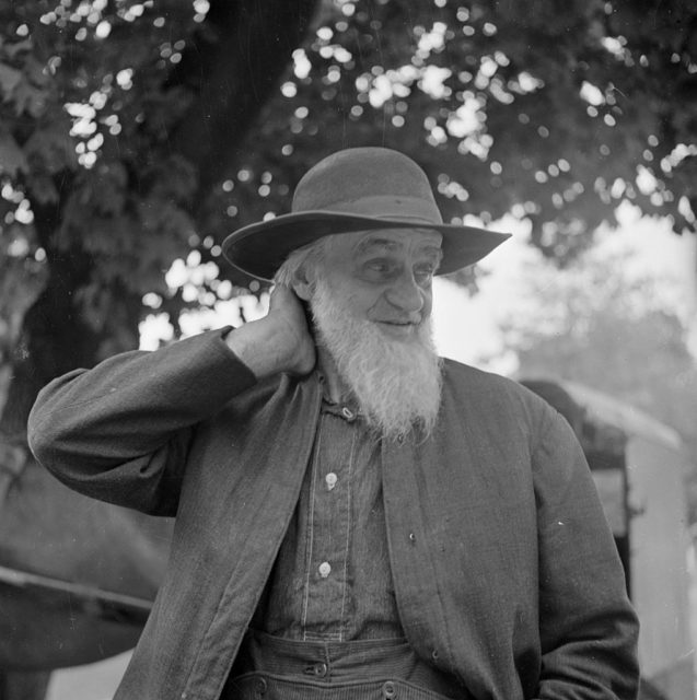 Amish man rubbing his neck