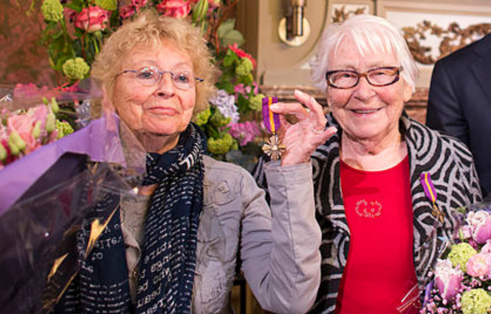 Freddie and Truus Oversteegen holding up their War Mobilization Cross