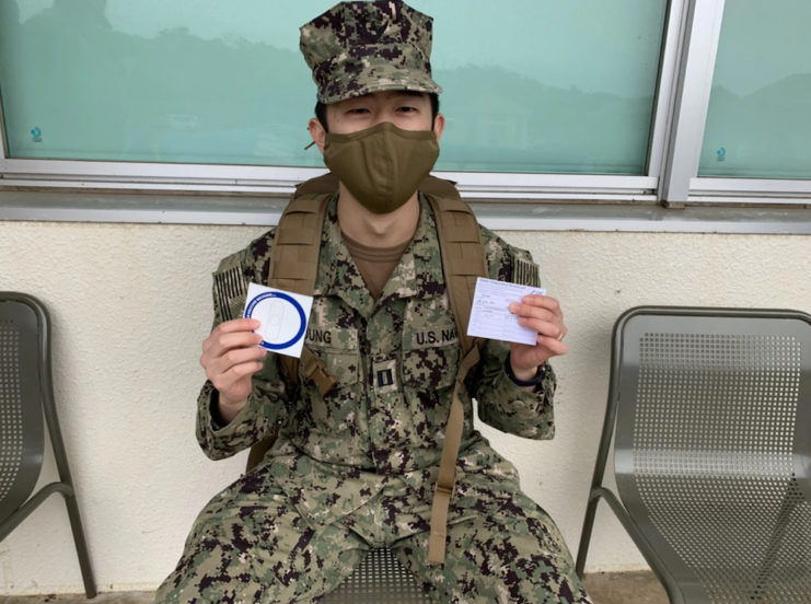 Lt. Winston Young holding up his COVID-19 vaccine certification