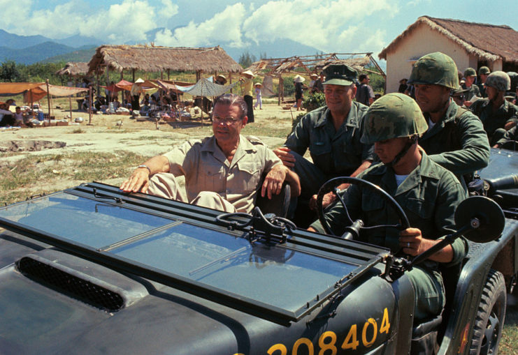 Robert McNamara with Marine Lieutenant Colonel David Clement and Major General Lewis W. Walt, riding in a Jeep driven by Corporal Felix A. Gallegos