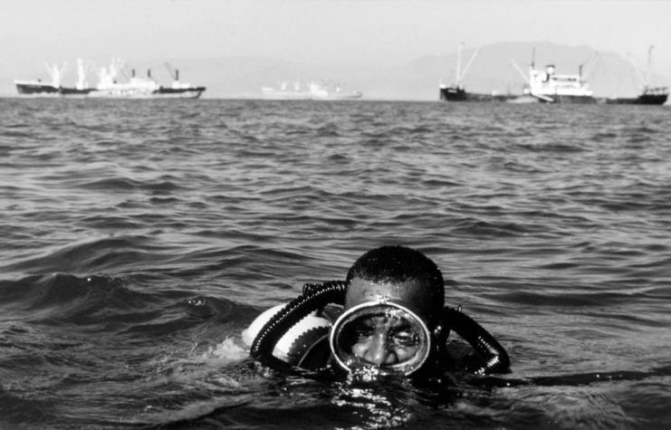 Mineman Second Class Franklin Marshall wading in the water in diving gear