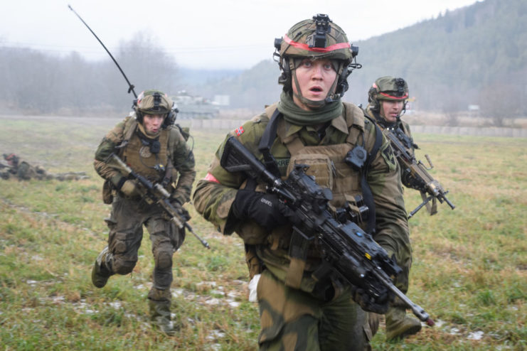 Three Norwegian soldiers running in a field