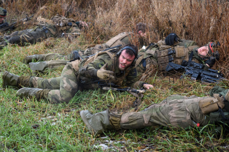 Norwegian soldiers lying on their stomachs in the grass