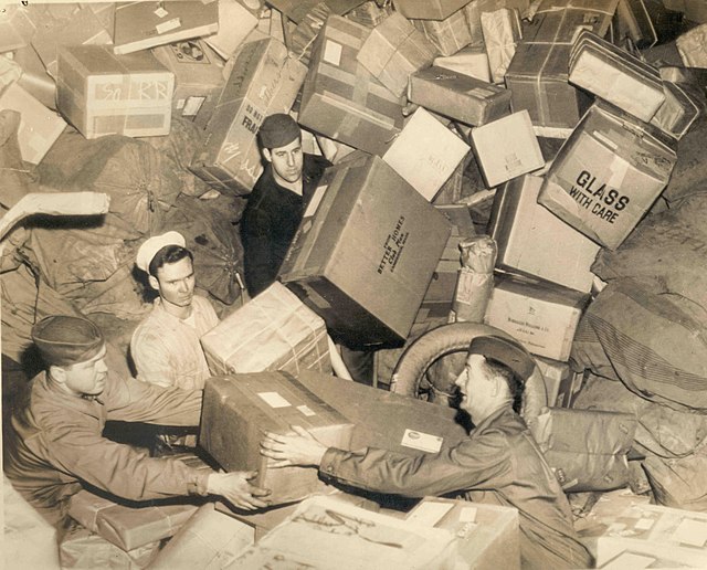 Four American soldiers surrounded by packages