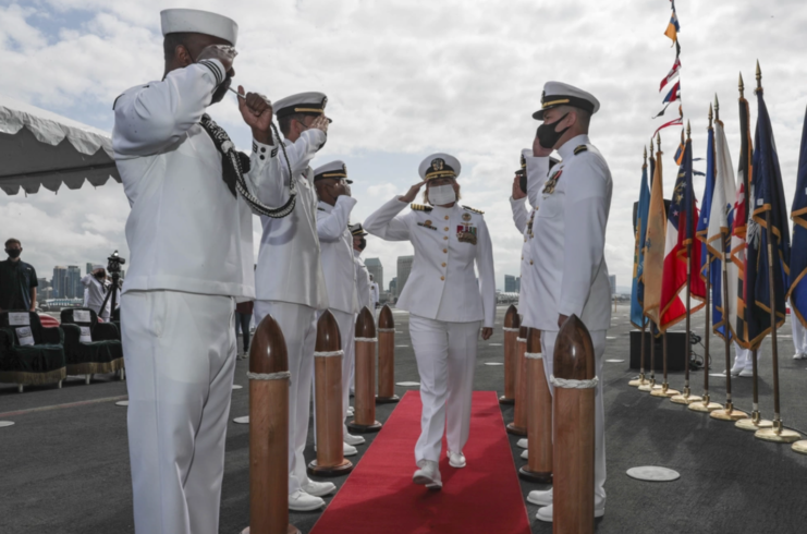 Capt. Amy Bauernschmidt walking between fellow Navy personnel