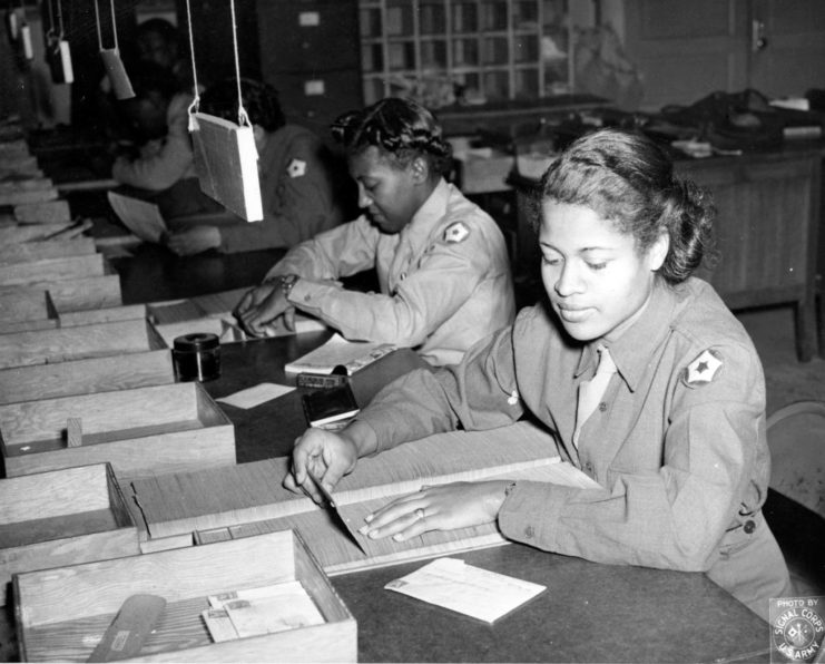 Members of the Women's Army Corps sitting at a table, sorting mail