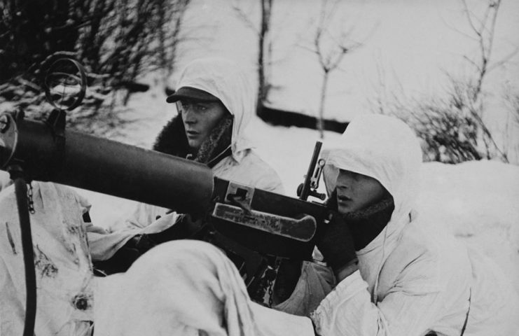 Two Finnish soldiers sitting in the snow with an anti-aircraft machine gun