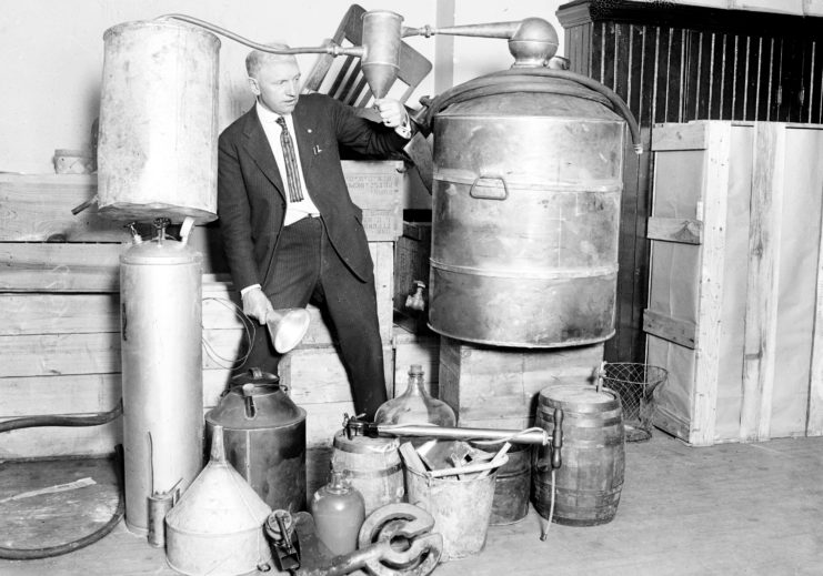 An investigator looks at a moonshine container during a Chicago bust