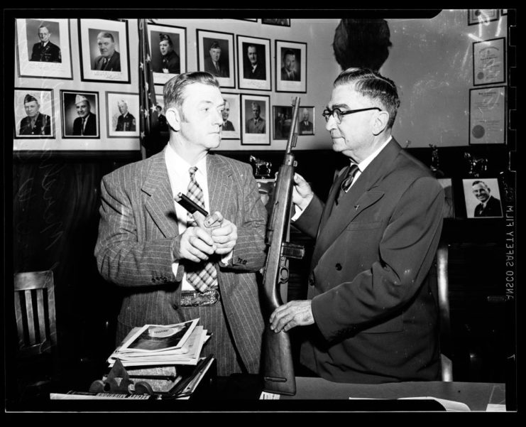 David Marshall Williams and Sheriff Eugene W. Biscailuz holding firearms