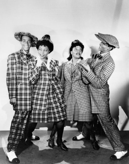 Four entertainers wearing Zoot Suits