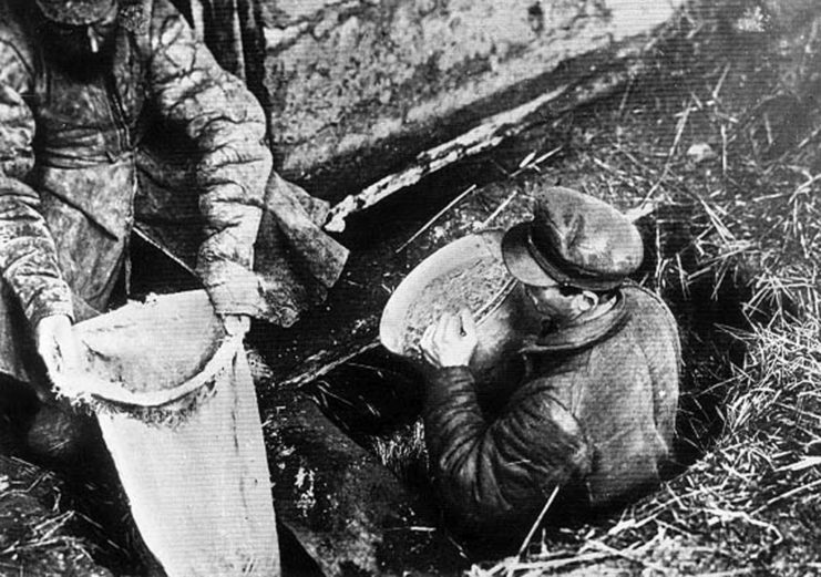 Soviet officials collecting grain in sacks