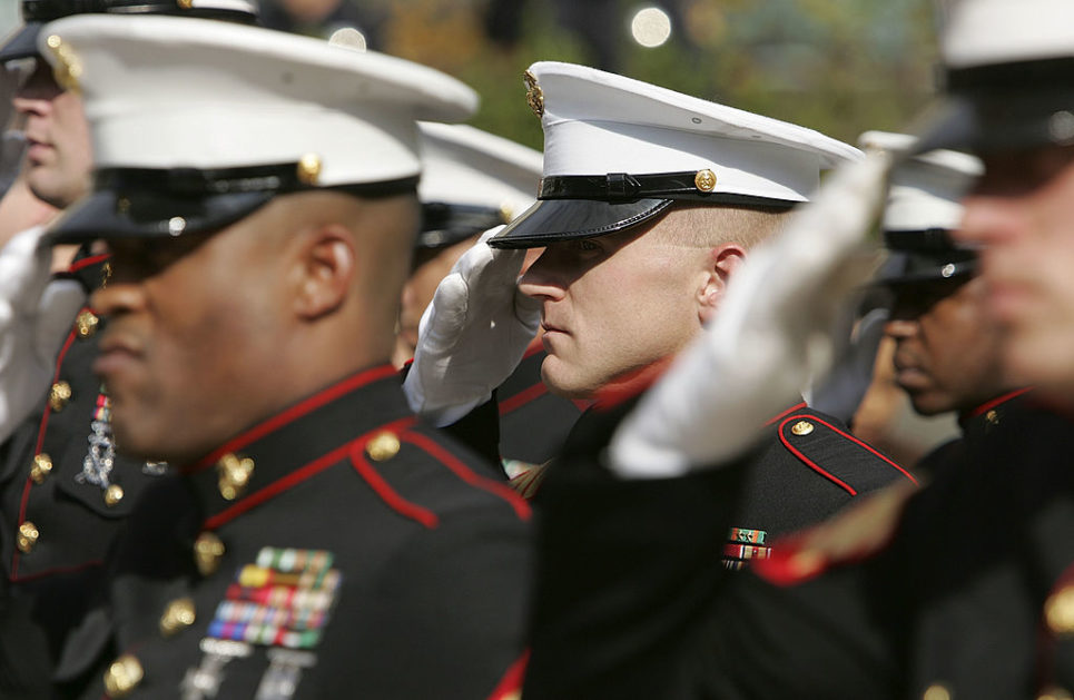 Members of the U.S. Marine Corp honor guard salute during the singing of the National Anthem during the unveiling ceremony for the new 