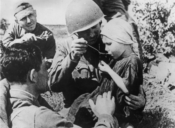 Red Army soldiers feeding a young child