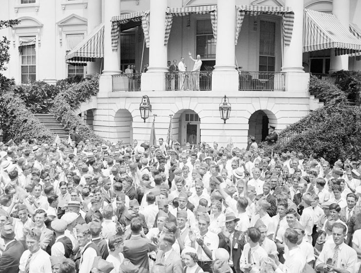 Franklin D. Roosevelt waving at a crowd gathered before the White House