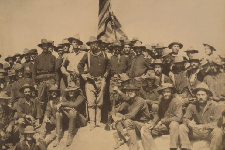 Teddy Roosevelt and the Rough Riders stand at the top of San Juan Hill