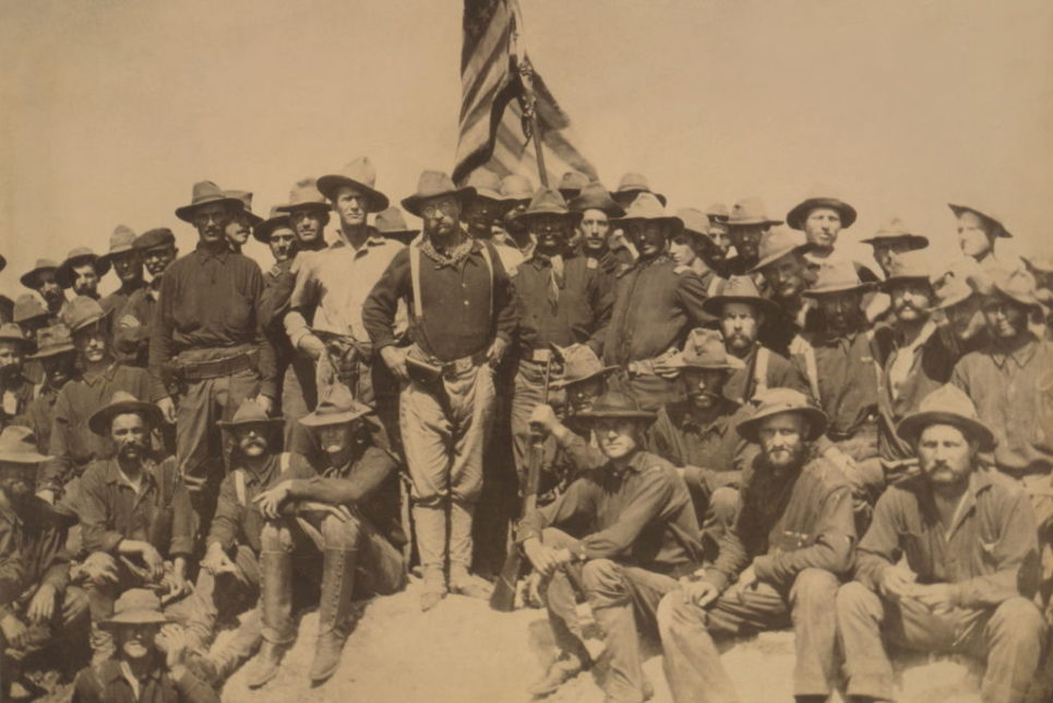 Teddy Roosevelt and the Rough Riders stand at the top of San Juan Hill