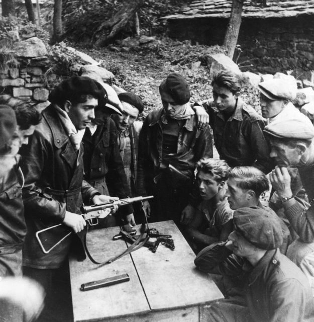 Members of the French Resistance examining firearms on a table