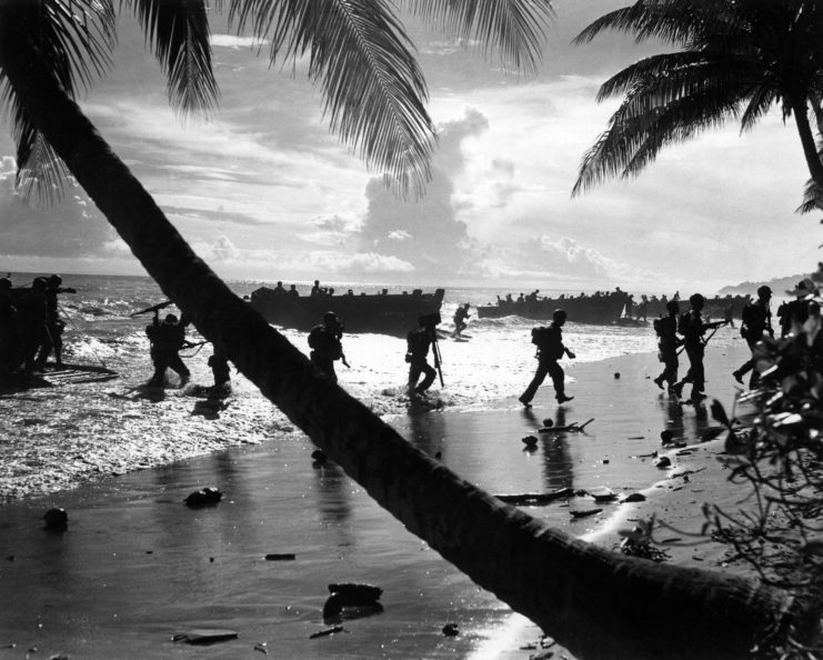 US Marines walking across the beach on Guadalcanal