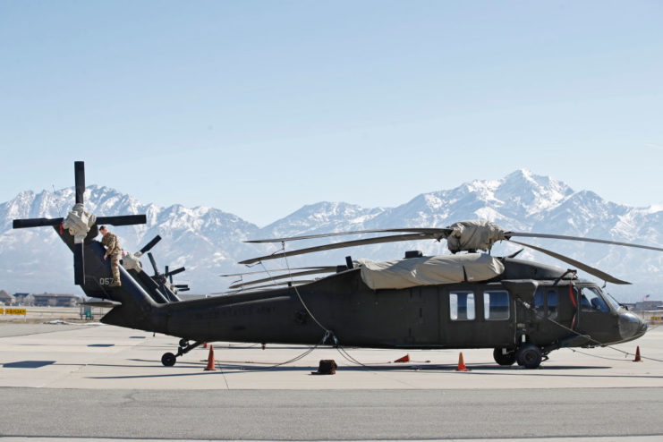 Black Hawk on the tarmac, with personnel examining the rotor