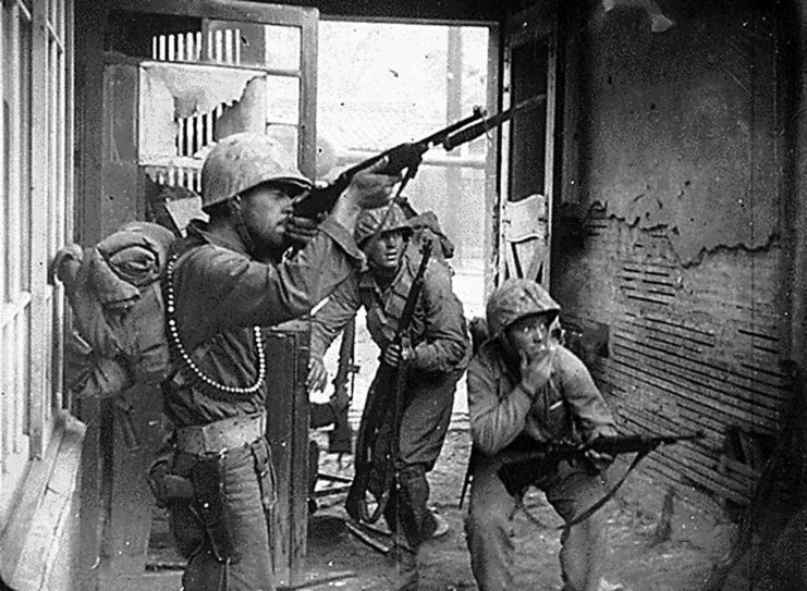 UN troops entering a building with guns raised