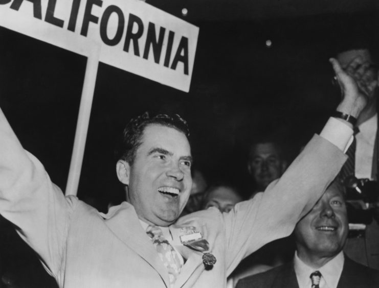 Richard Nixon throwing his arms up in victory