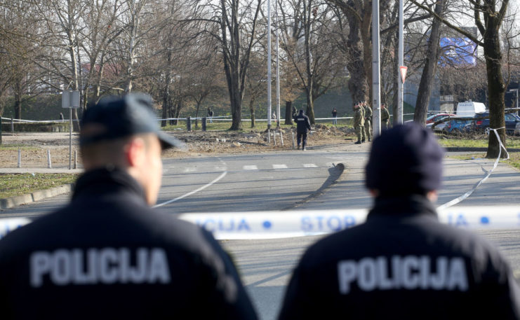 Two Croatian police officers standing behind police tape