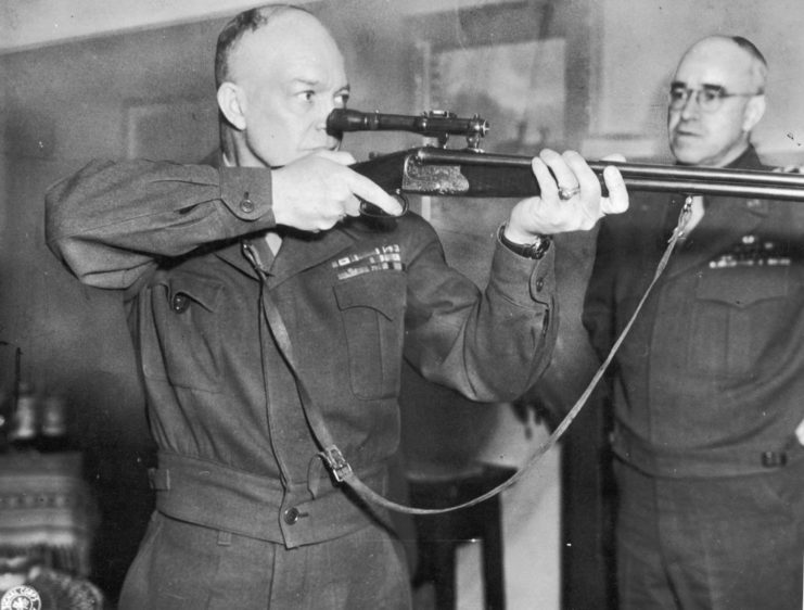 Dwight D. Eisenhower aiming a rifle while Omar Bradley watches