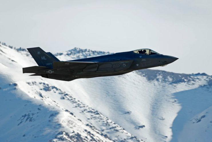 F-35 Lightning II flying over snowcapped mountains