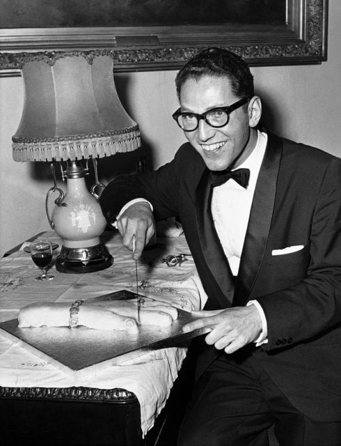 Tom Lehrer cuts into a cake in 1959