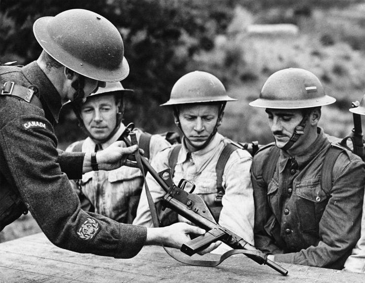 British soldiers being taught how to use a STEN submachine gun.