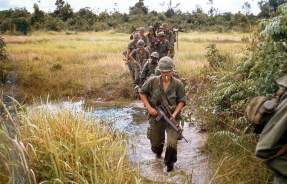 Infantrymen walking through a creek