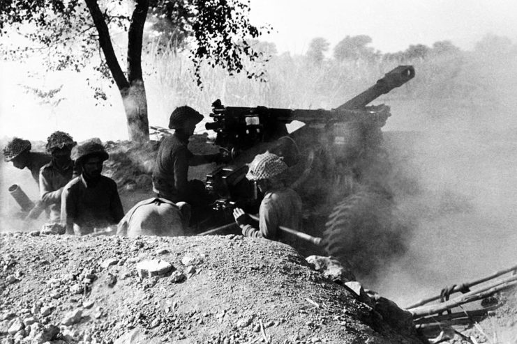 Indian troops in a trench, firing weapons