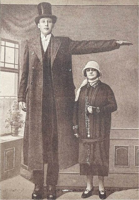 Jakob Nacken standing with his arm raised over a woman