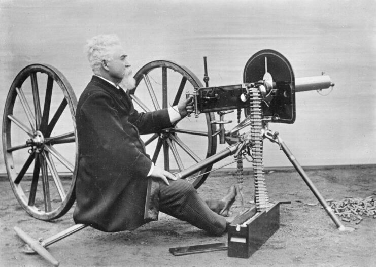 Hiram Maxim sitting with a Maxim gun